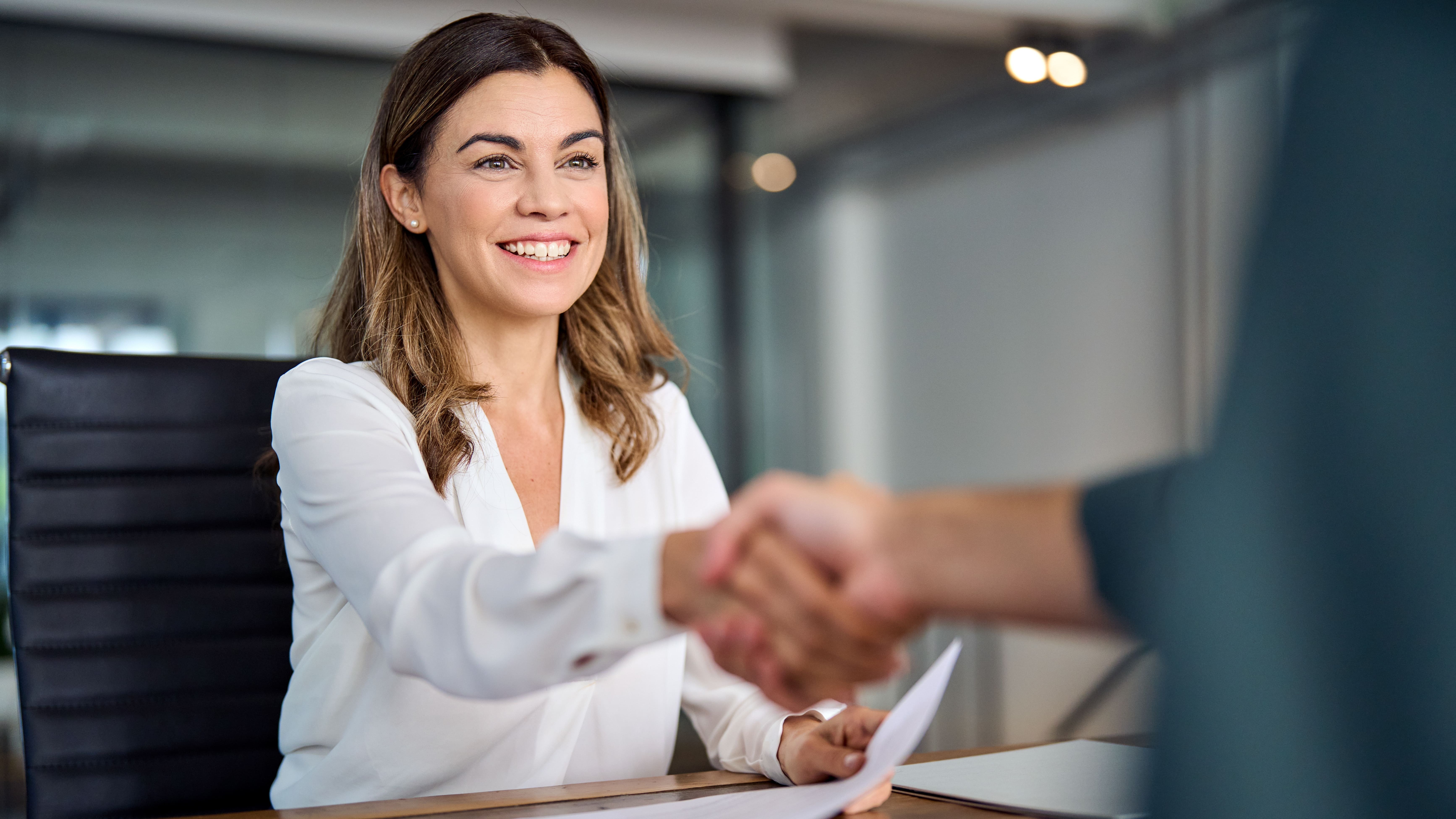 Une femme serre la main d’un interlocuteur, illustrant la collaboration entre services grâce à vialytics.