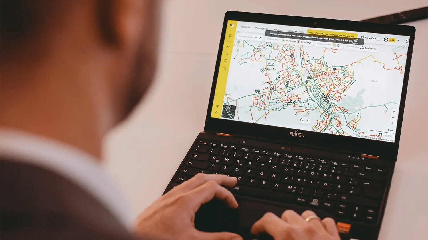 Un homme consulte le système vialytics sur son ordinateur portable. Une vue cartographique du système vialytics s’affiche à l’écran.