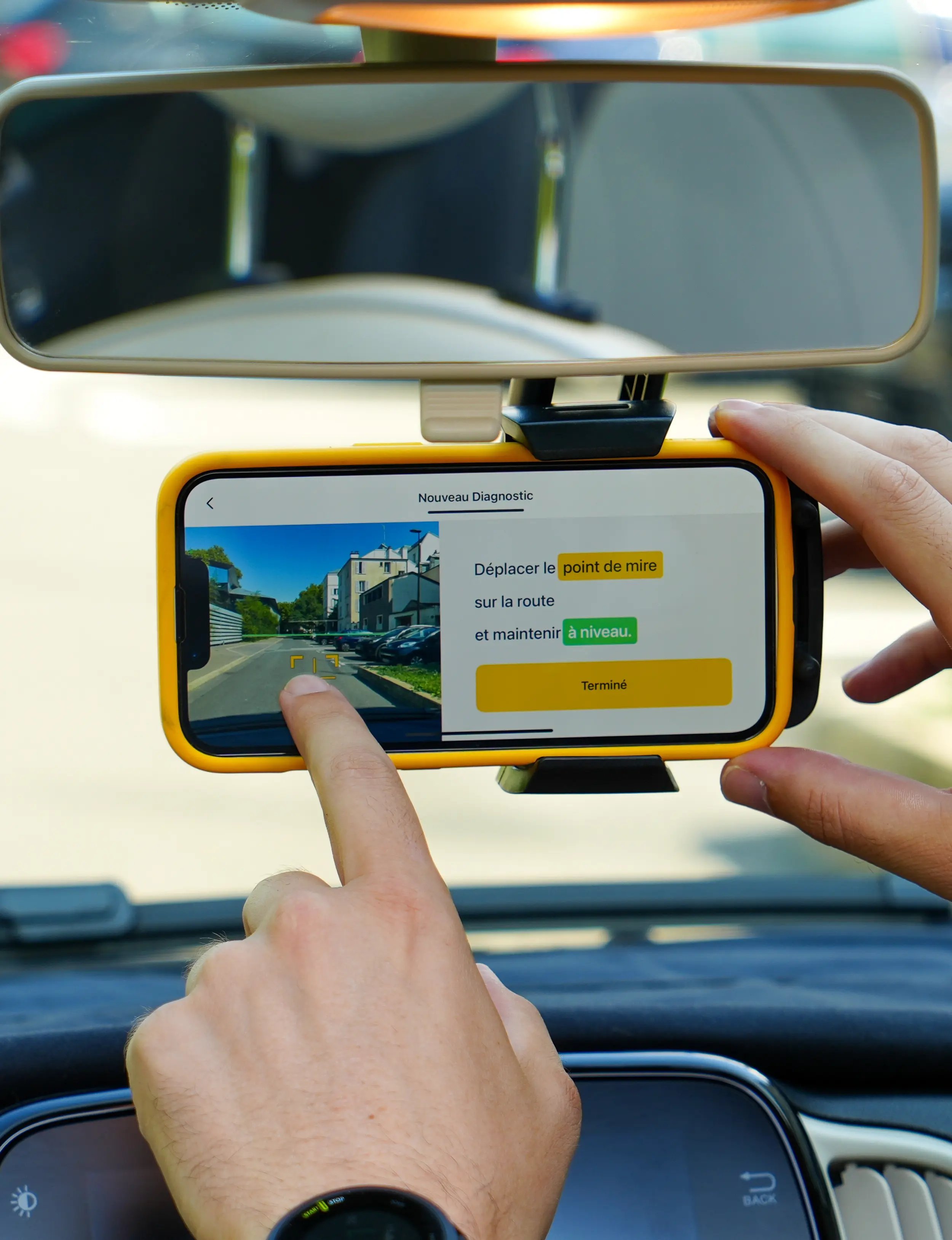 Smartphone fixé au pare-brise d’un véhicule, utilisant l’application vialytics pour capturer et analyser l’état de la chaussée lors d’un diagnostic routier.