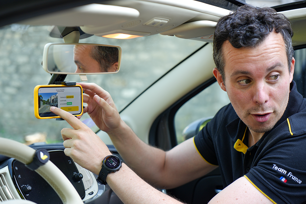 Un technicien vialytics installe un smartphone sur le pare-brise d'un véhicule pour démarrer une inspection routière avec l'application, en conditions réelles.