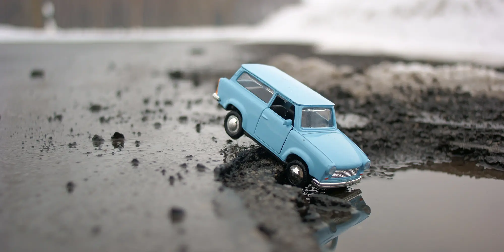 Voiture endommagée par un nid-de-poule sur une route française